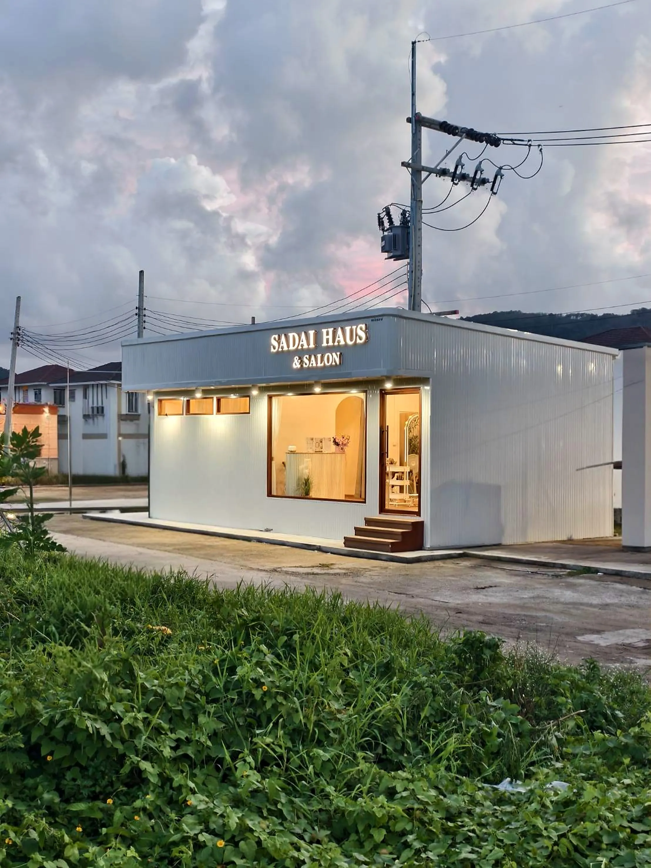 หน้าร้าน Sadai Haus ยามเย็น ป้ายไฟสว่างและแสงอบอุ่นภายในร้าน